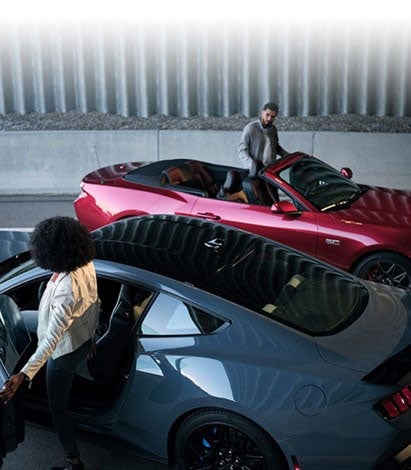 Two people exiting their parked 2024 Ford Mustang® coupe and convertible | Conroy Motor Corporation in Java Center NY