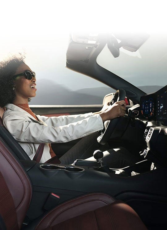 Person sitting in the driver’s seat of a 2024 Ford Mustang® convertible | Conroy Motor Corporation in Java Center NY